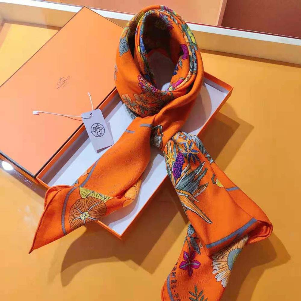 Close-up detail of Hermes signature on the orange silk scarf corner