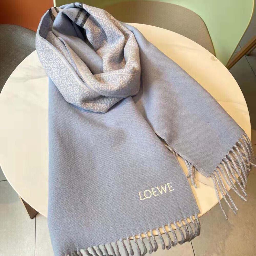 Detail shot of Loewe embossed logo on blue wool and cashmere scarf
