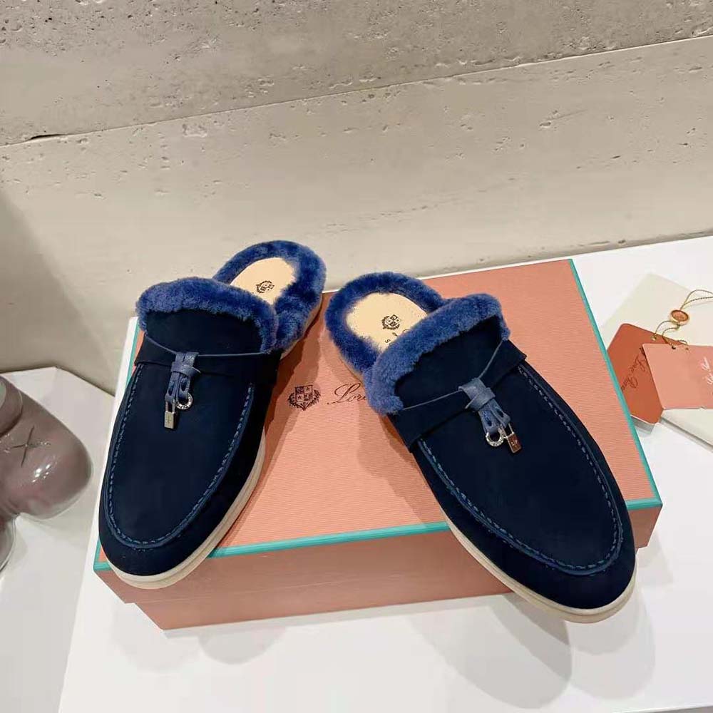 Close-up on silver charm detail of Loro Piana navy loafers