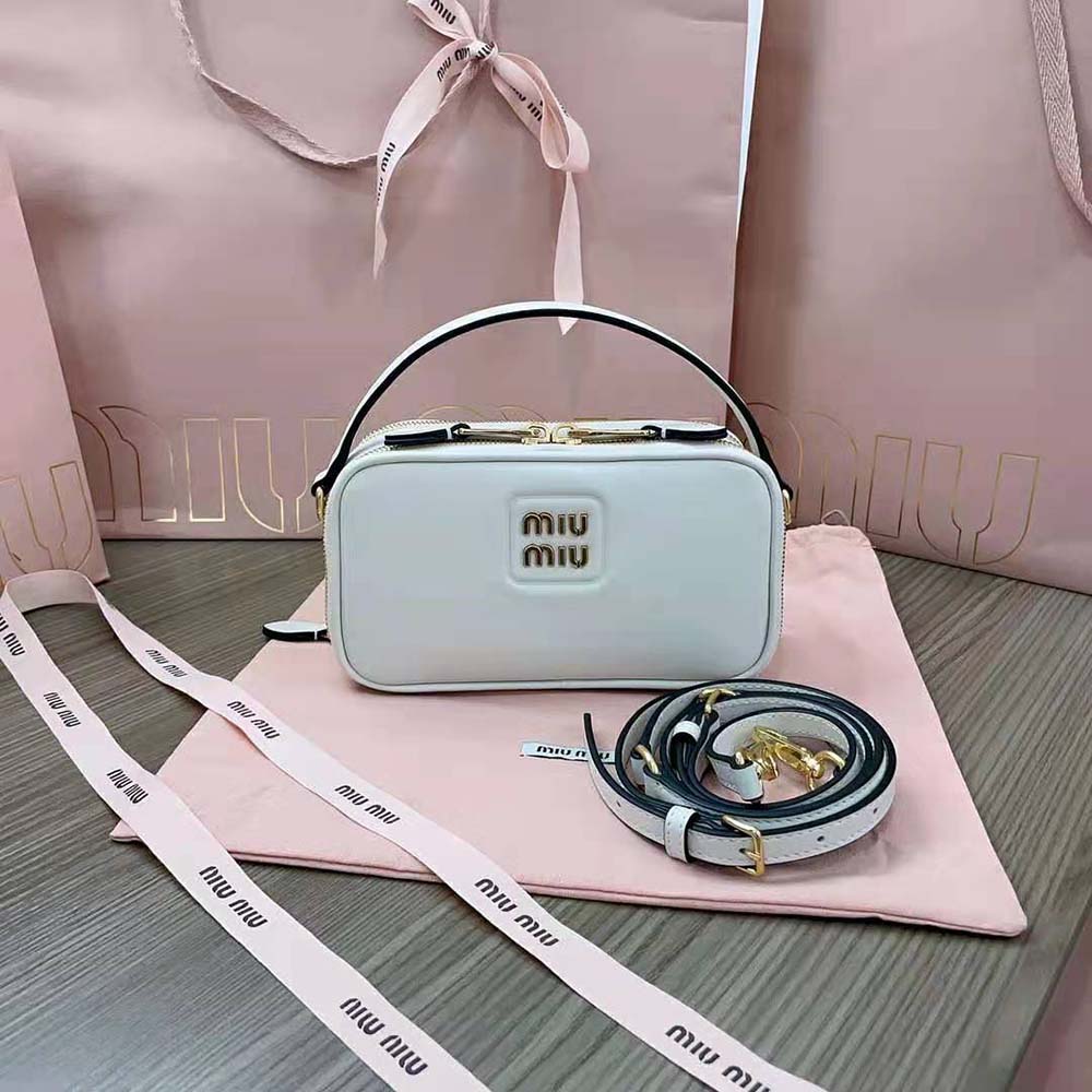 Close-up of metal lettering logo on white Miu Miu leather bag