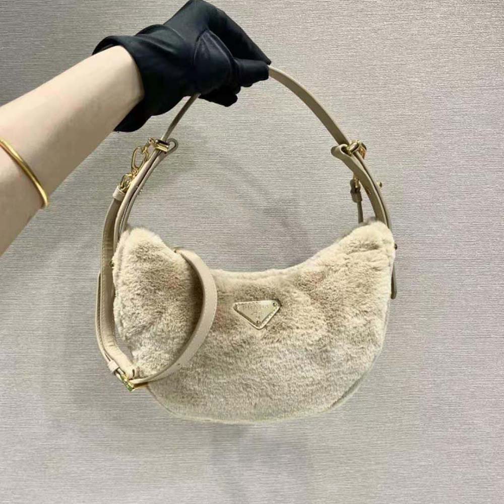 Close-up of gold hardware on Prada Women Arqué Shearling and Leather Shoulder Bag-Beige