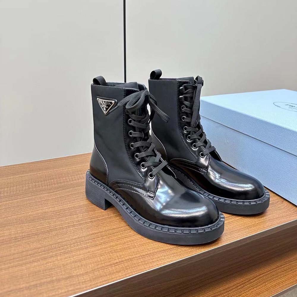 Close-up detail of brushed leather and lace-up closure on Prada boots