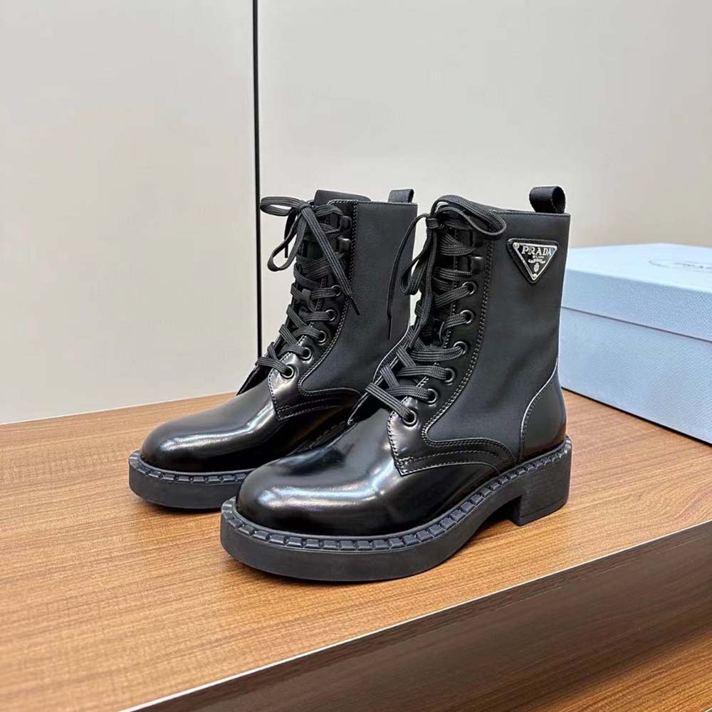 Top-down view highlighting black Re-Nylon fabric and metal eyelets on Prada boots