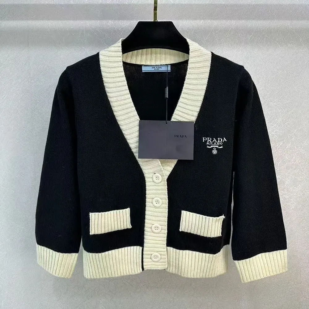 Close-up of Prada logo buttons on black cashmere and silk cardigan