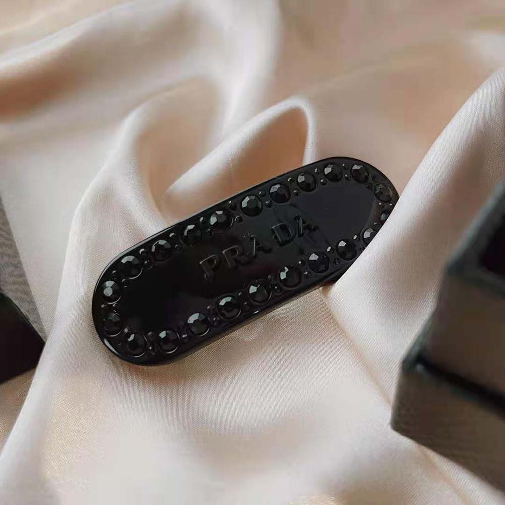 Side angle showing metal clasp of Prada Women Plex Hair Clip