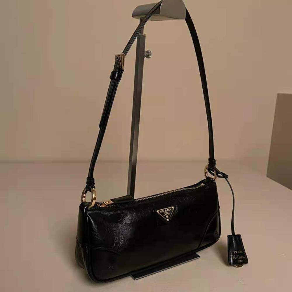 Close-up of silver triangular logo on Prada Women Re-Edition 2002 shoulder bag