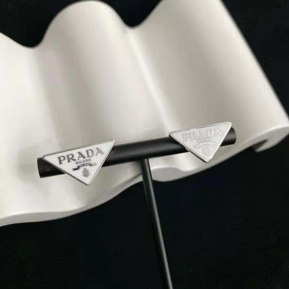 Close-up on Prada Symbole detail on white silver earrings
