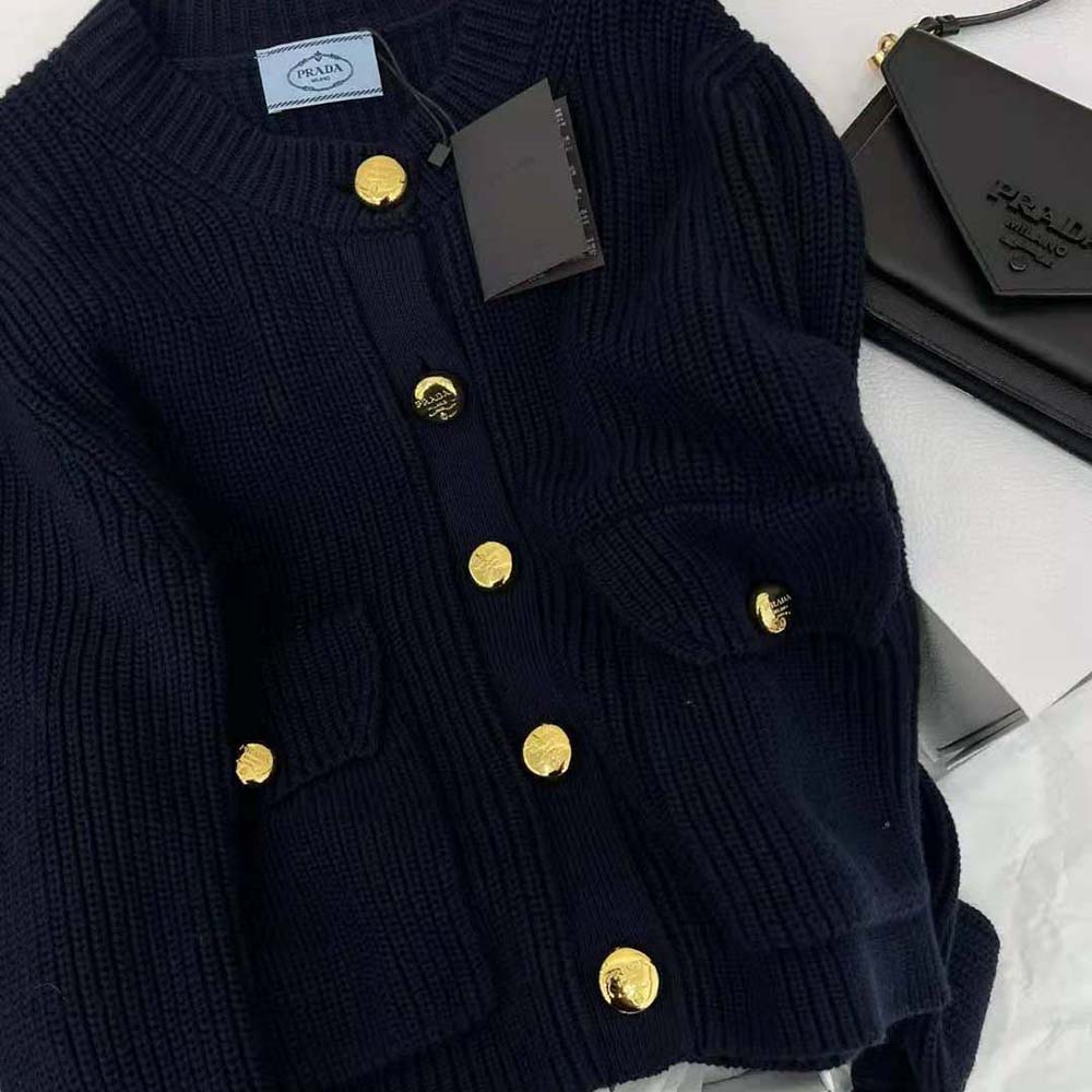 Close-up of gold buttons on Prada Wool Cardigan black fabric