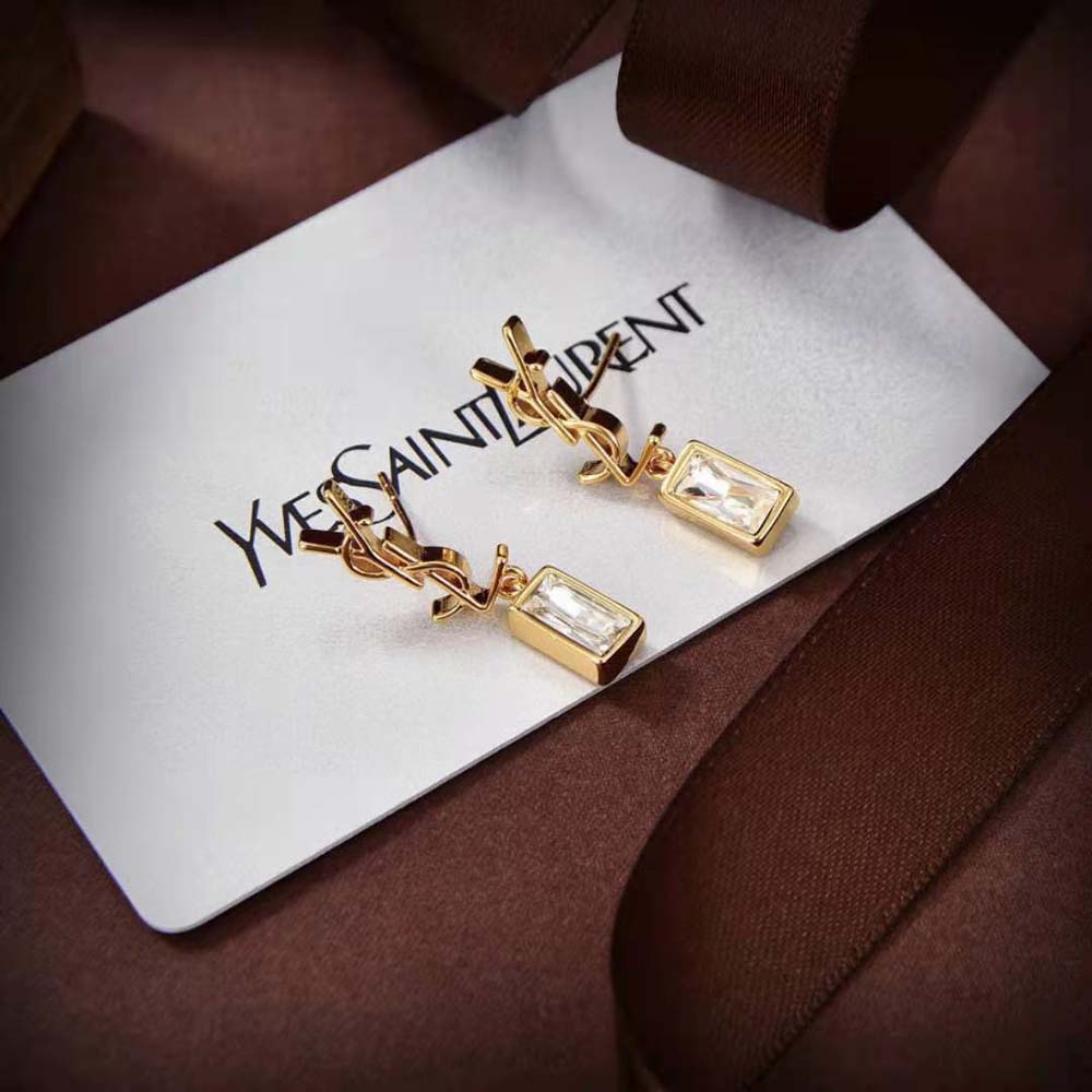 Styled shot highlighting gold metal and signature design of Saint Laurent YSL single earring