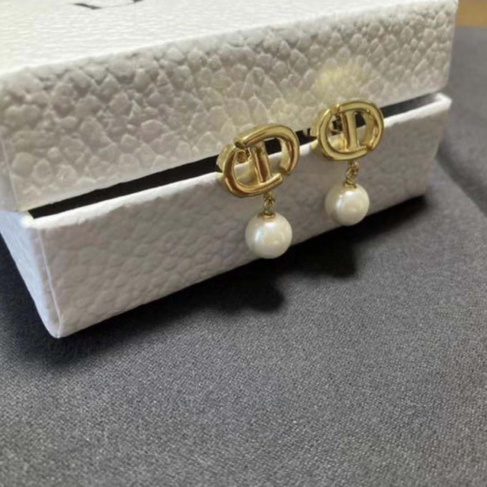 Close-up detail of gold-finish 'CD' logo on Dior Women CD Navy Earrings