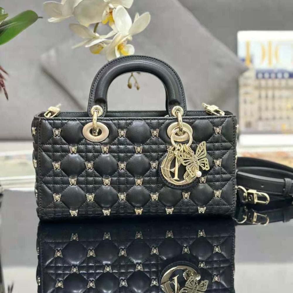 Close-up of gold-finish butterfly studs on Dior Lady D-joy Bag