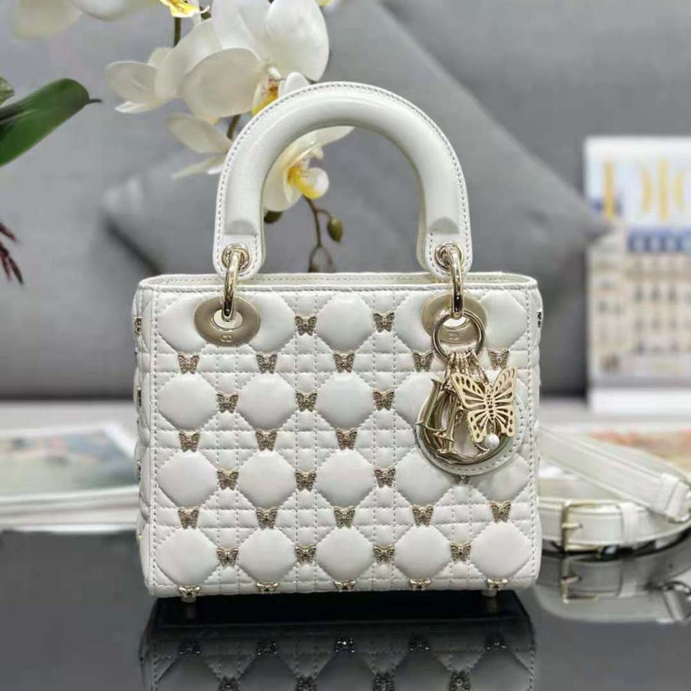 Close-up of gold-finish butterfly studs and cannage stitching on Lady Dior bag