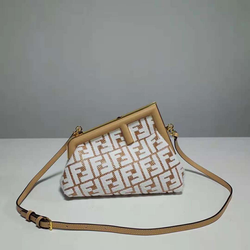 Close-up of white tapestry fabric and gold hardware on Fendi bag