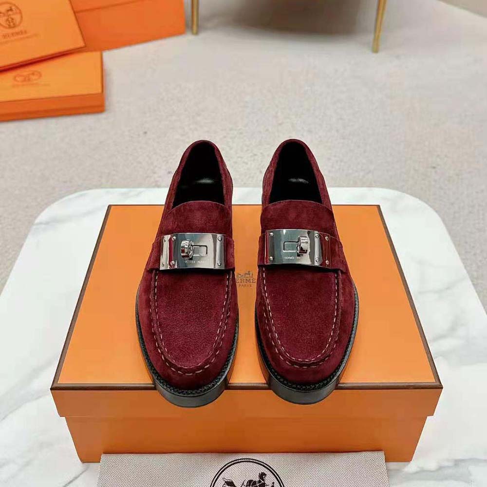Close-up detail of maroon suede and Hermes hardware on loafer