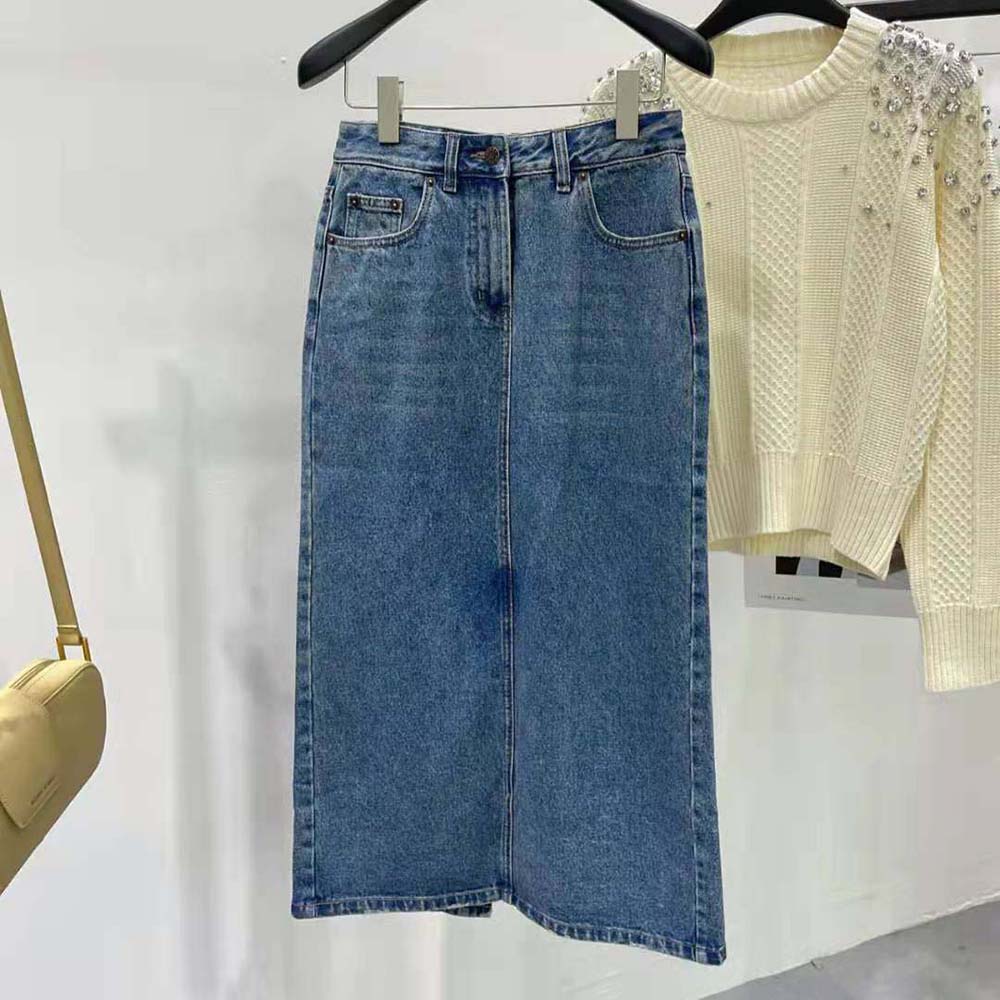 Close-up of Prada logo embossed hardware on denim maxi-skirt