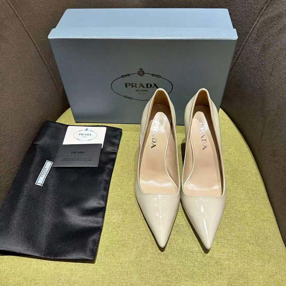 Close-up of signature Prada logo on white patent leather pumps