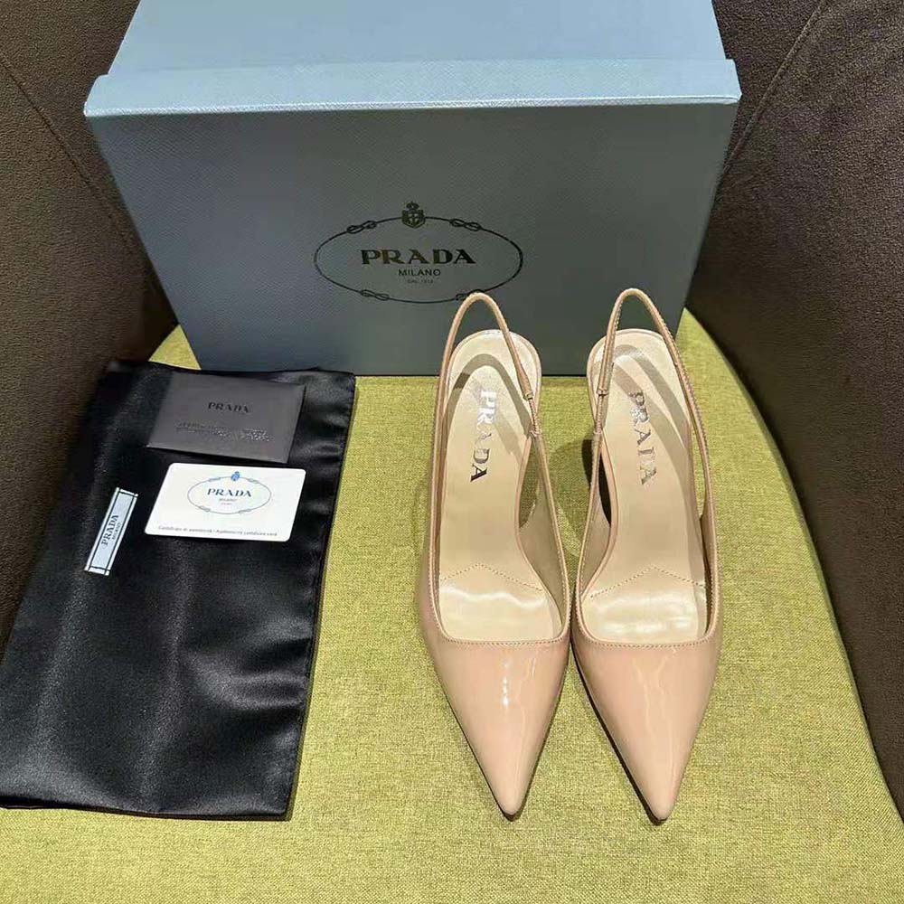 Close-up of gold Prada logo hardware on pink patent leather slingbacks