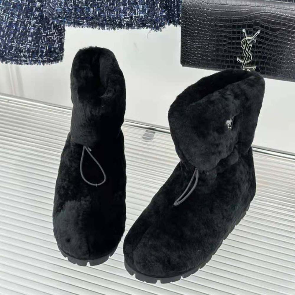 Close-up of enameled metal triangle logo on Prada Women Shearling Booties Black