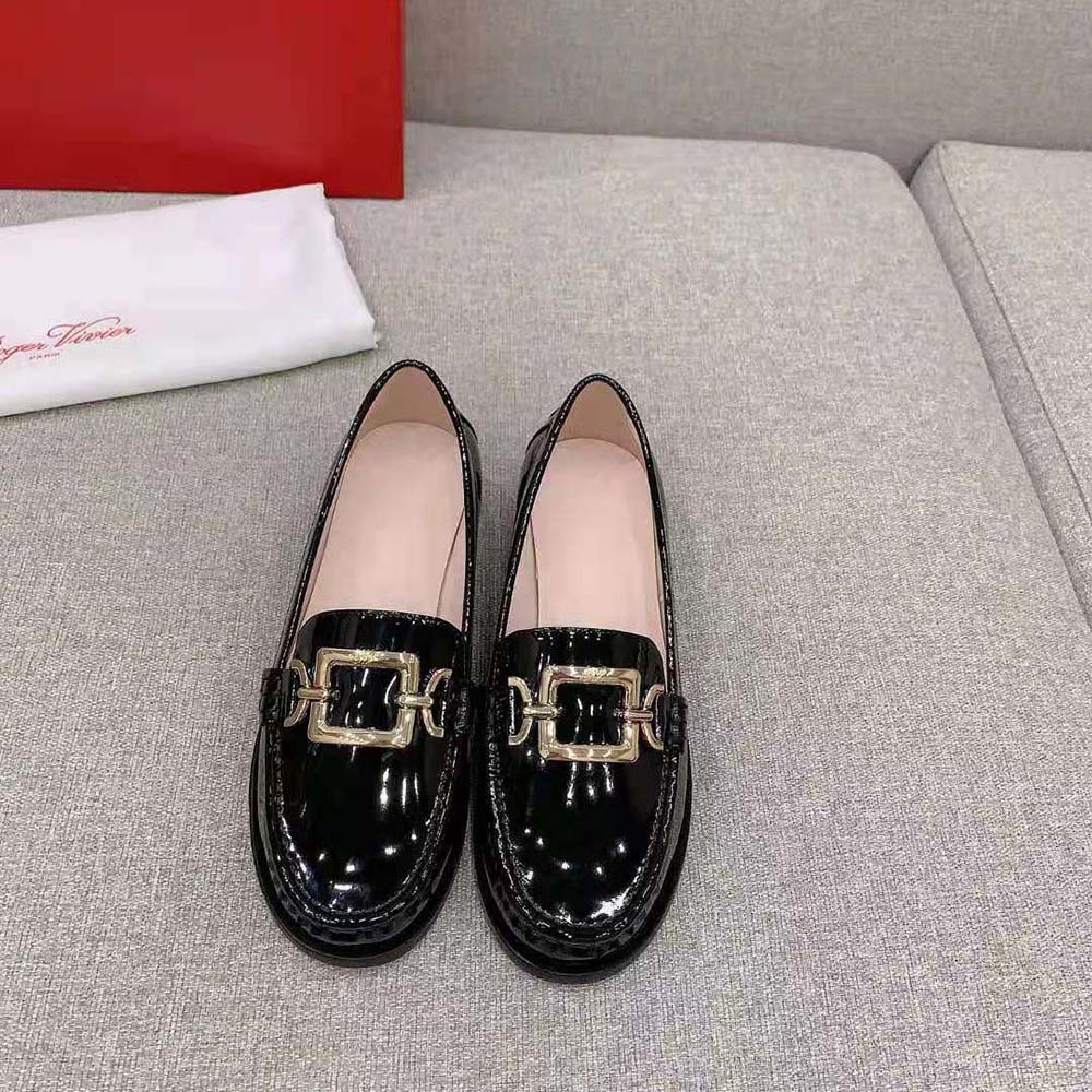 Close-up of silver metal buckle detail on Roger Vivier black patent loafers