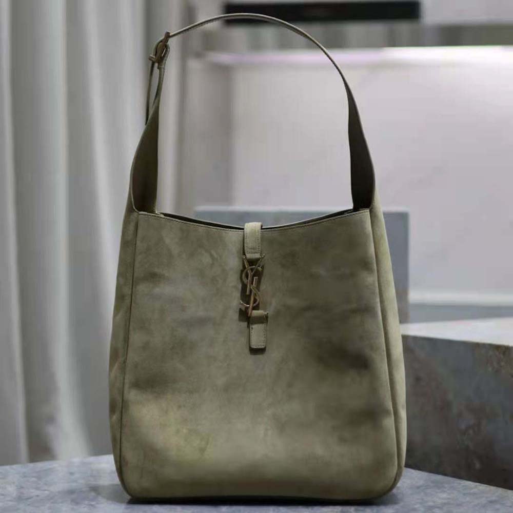 Close-up of gold YSL logo hardware on suede-green shoulder bag