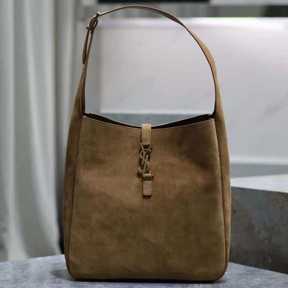 Close-up of gold YSL hardware on suede-brown bag flap