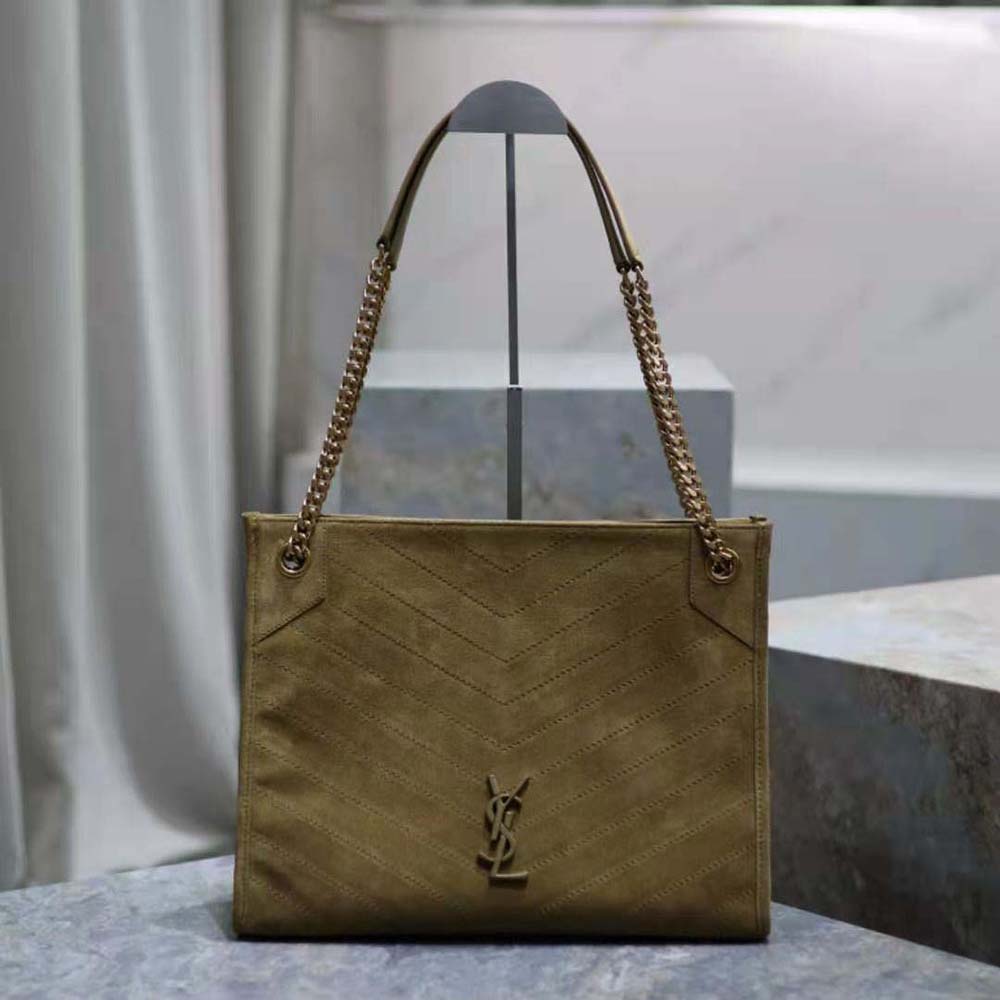 Close-up of gold YSL logo and chain strap on suede-green bag