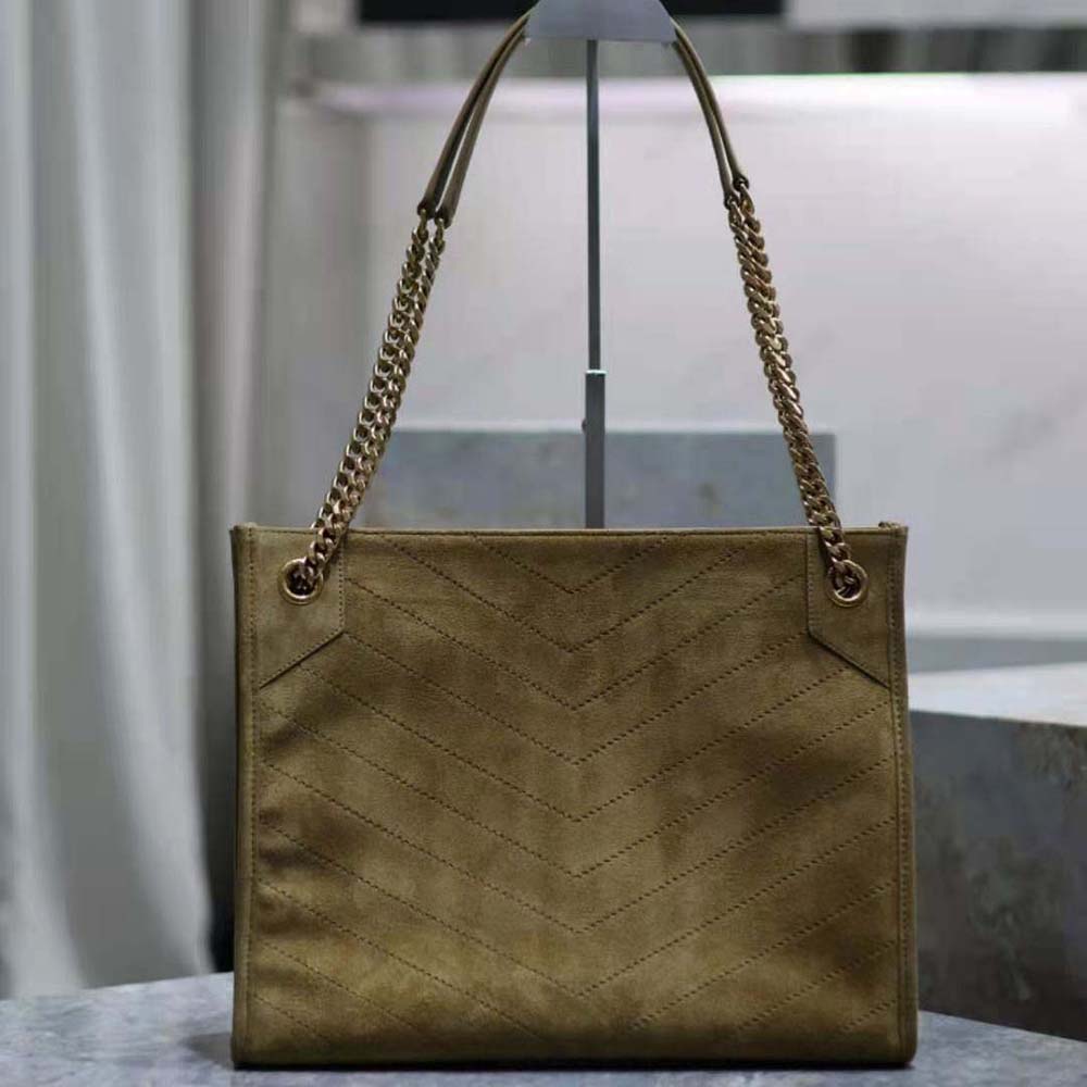 Side angle showing textured suede and flap closure of YSL Niki Medium bag