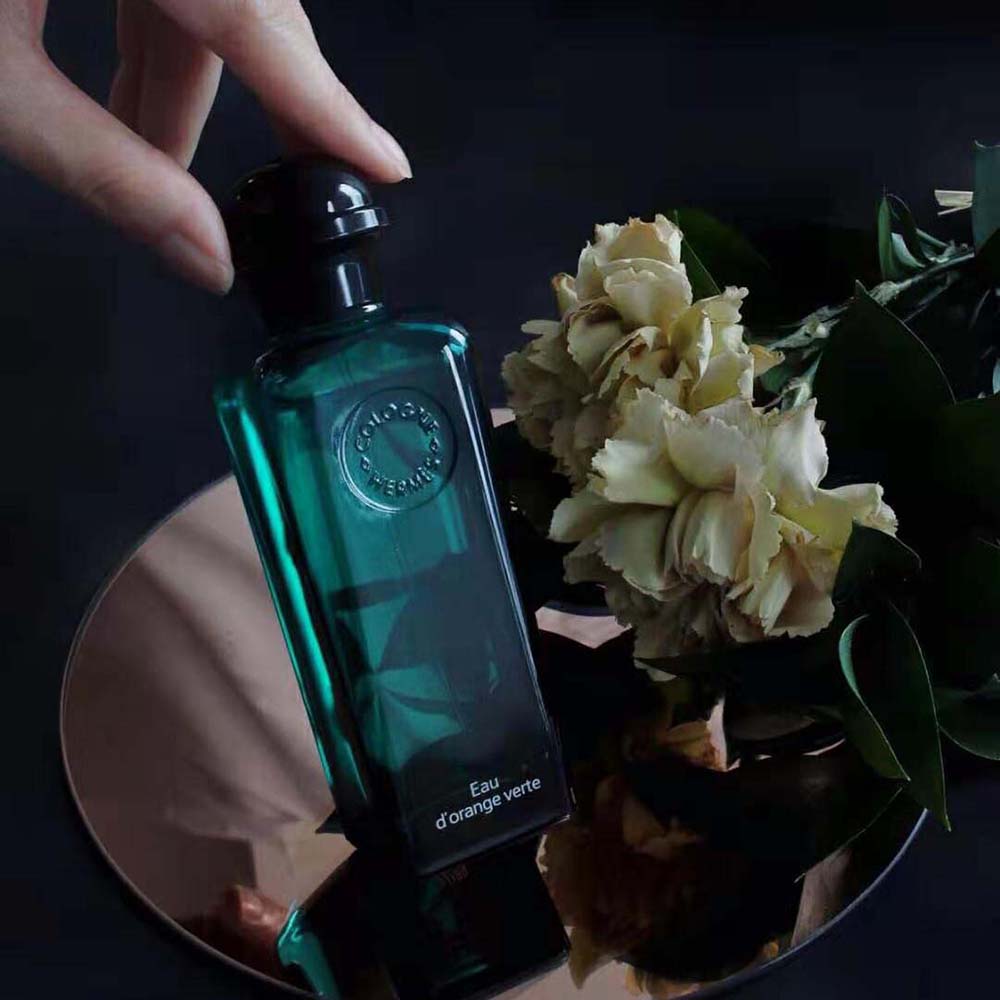 Close-up detail of green glass and spray nozzle on Hermes Eau D’orange Verte