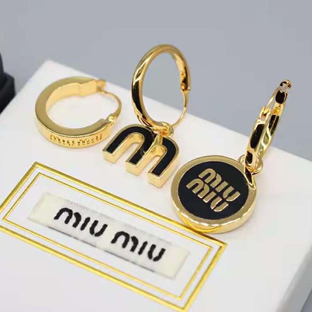 Close-up detail of polished silver-tone hardware on Miu Miu enamel earrings