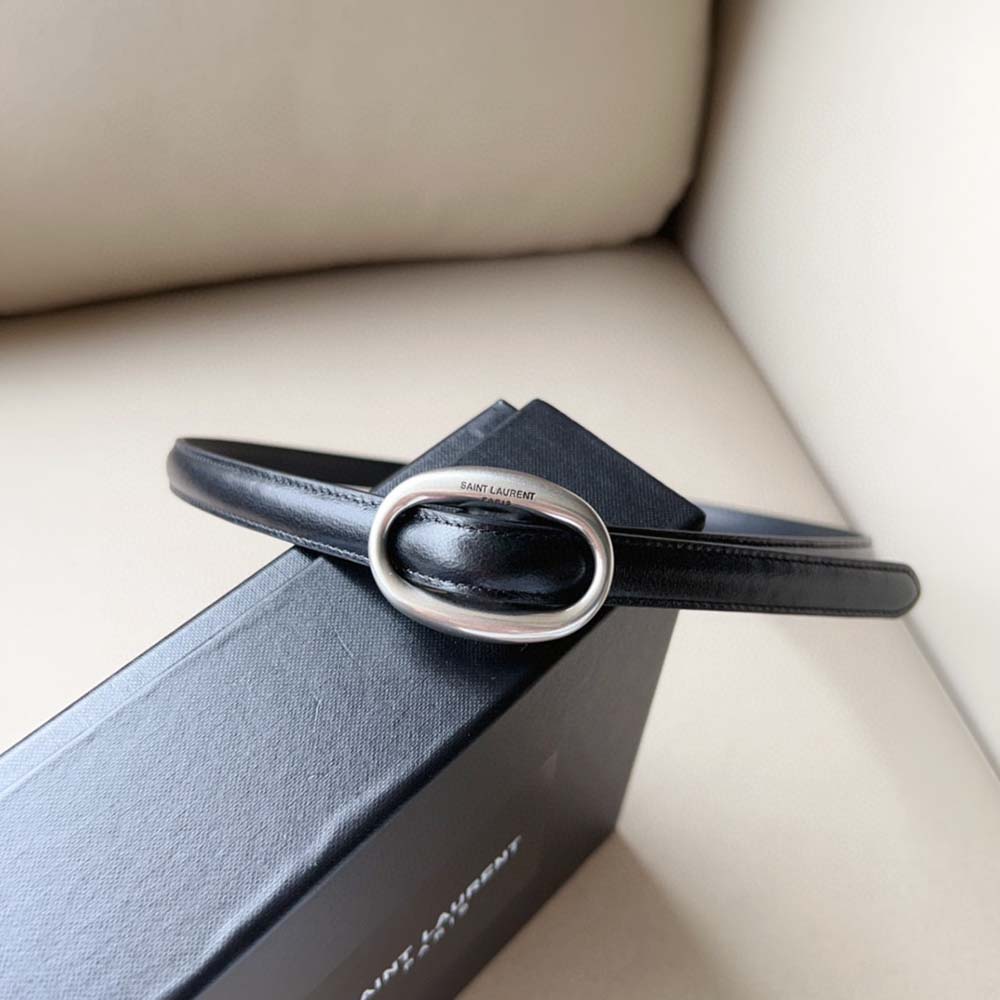 Close-up of polished oval YSL buckle on Saint Laurent YSL thin leather belt