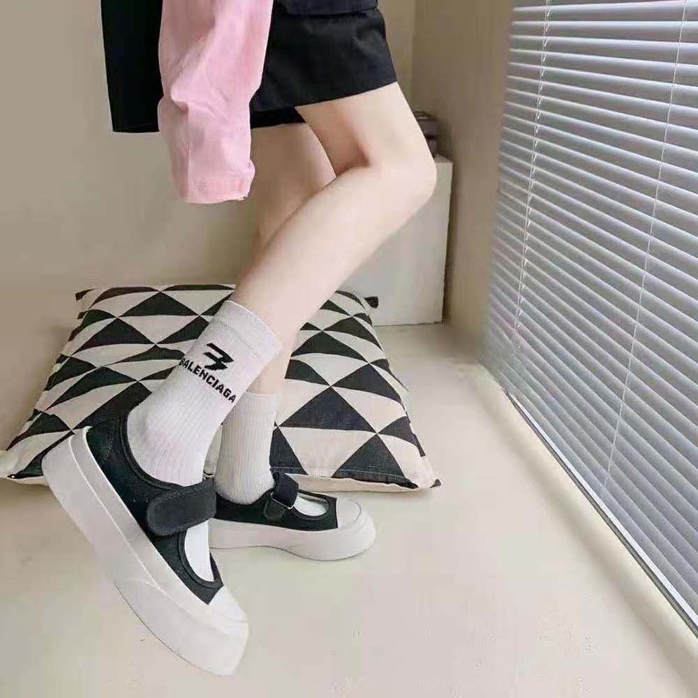 Close-up showing black Balenciaga 3B logo detail on white socks