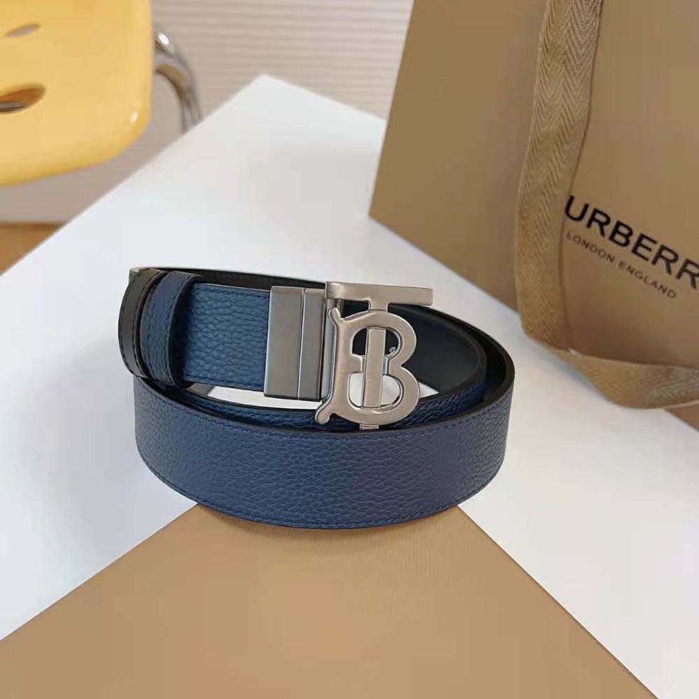 Side angle showing reversible black and navy leather belt by Burberry