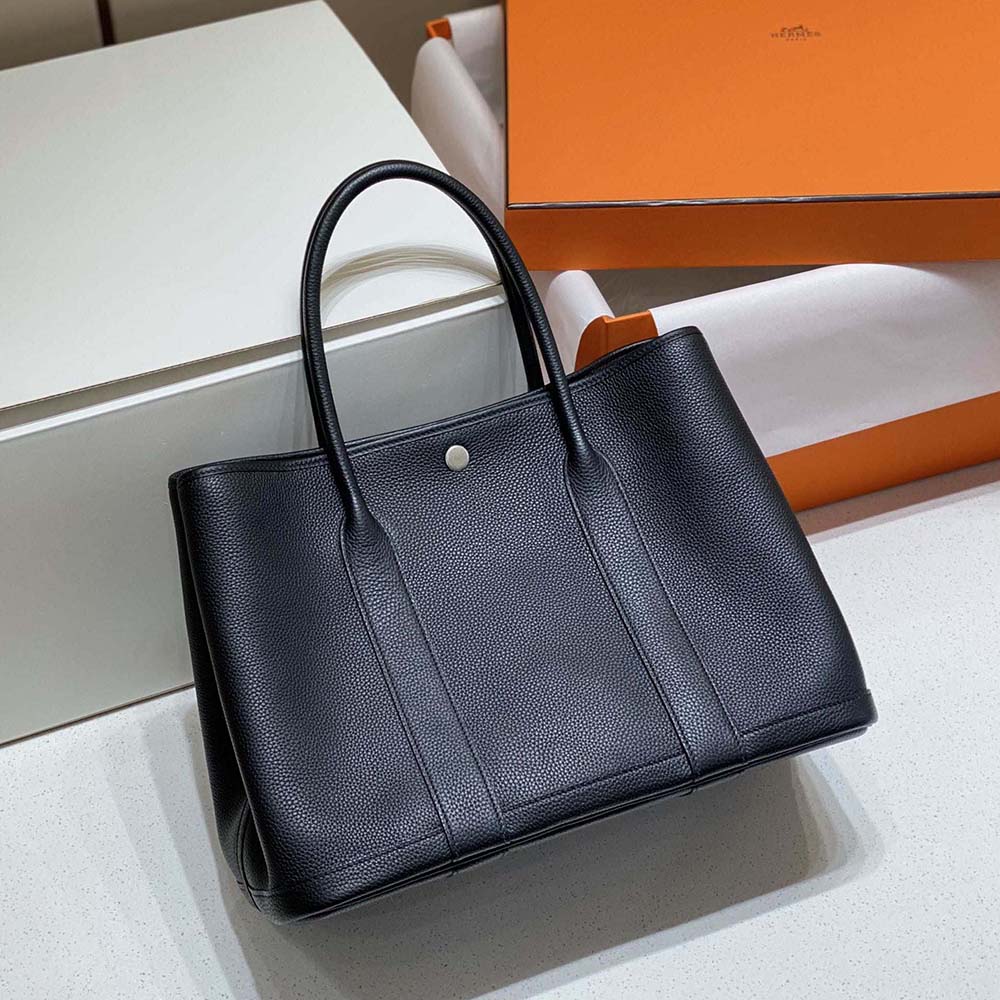 Close-up of smooth black leather and silver-tone hardware on Hermes bag