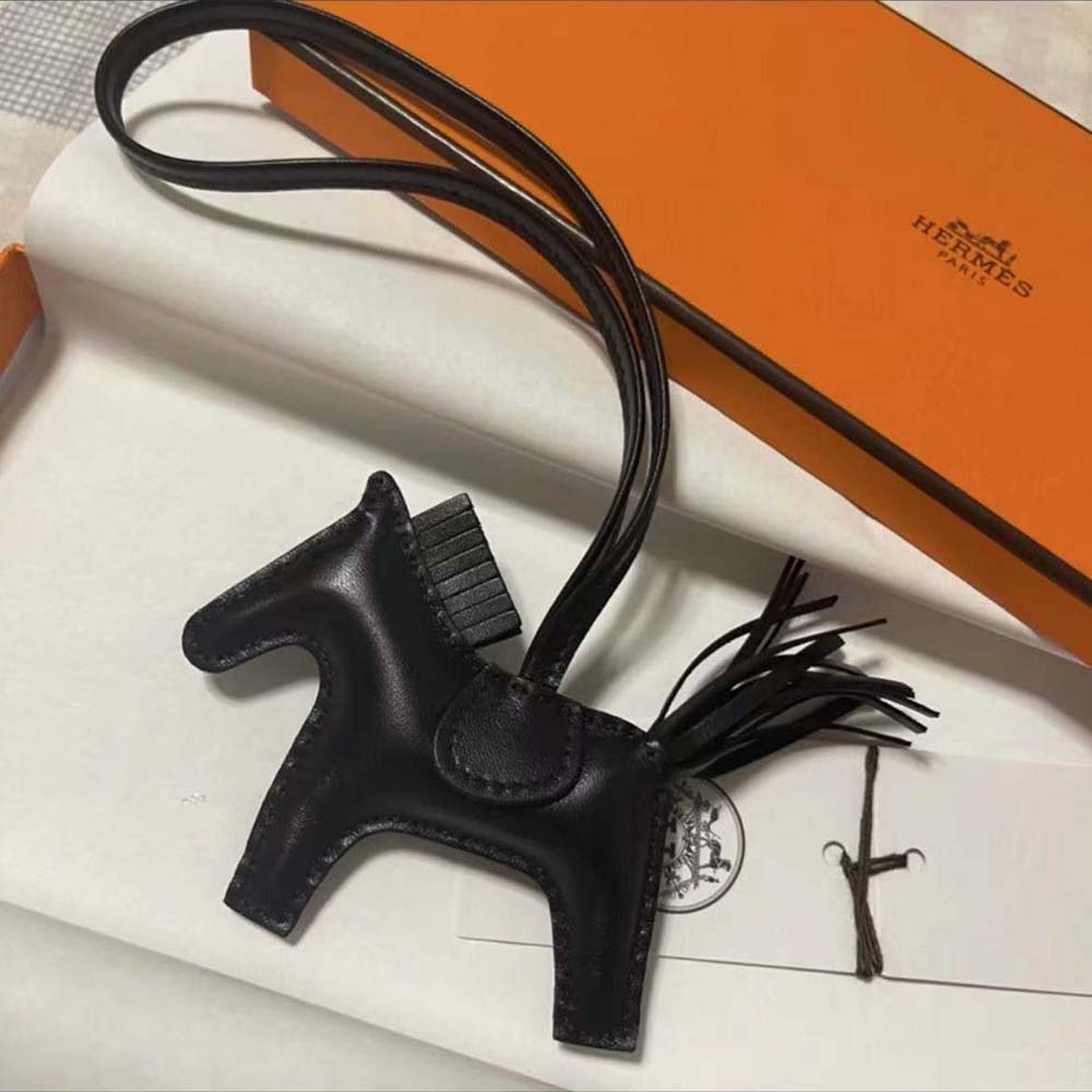 Close-up detail of black leather texture and hardware on Hermes Rodeo MM Charm