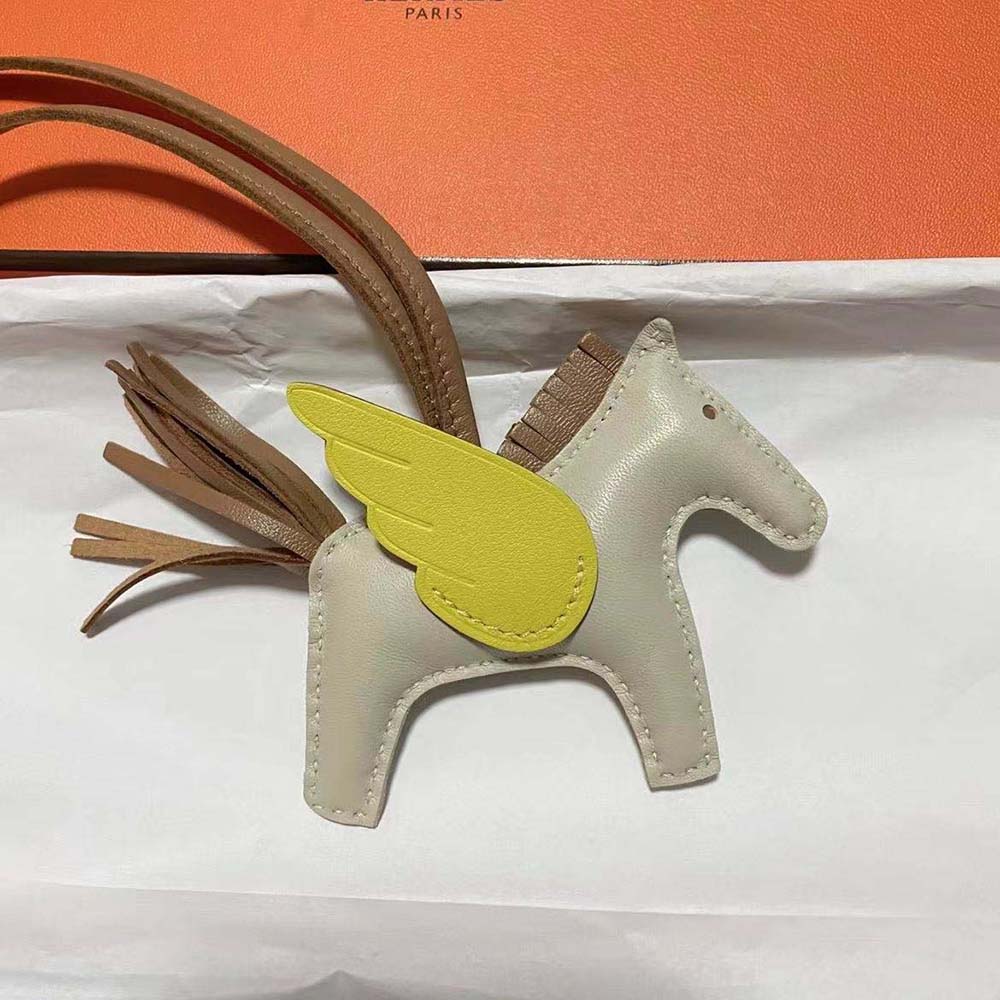 Close-up of gold-tone hardware on Hermes Rodeo Pegase MM Charm-Yellow