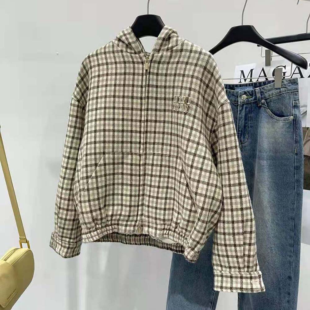Close-up of embroidered logo on brown check Miu Miu blouson jacket