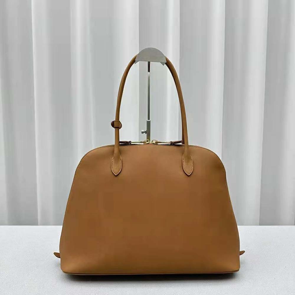 Side profile showing adjustable strap and gold hardware on Miu Miu leather bag