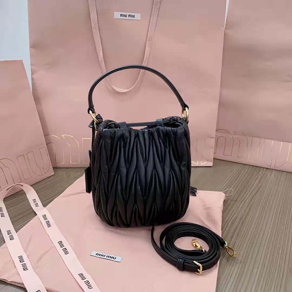 Side angle showing drawstring closure and silver hardware on Miu Miu bucket bag