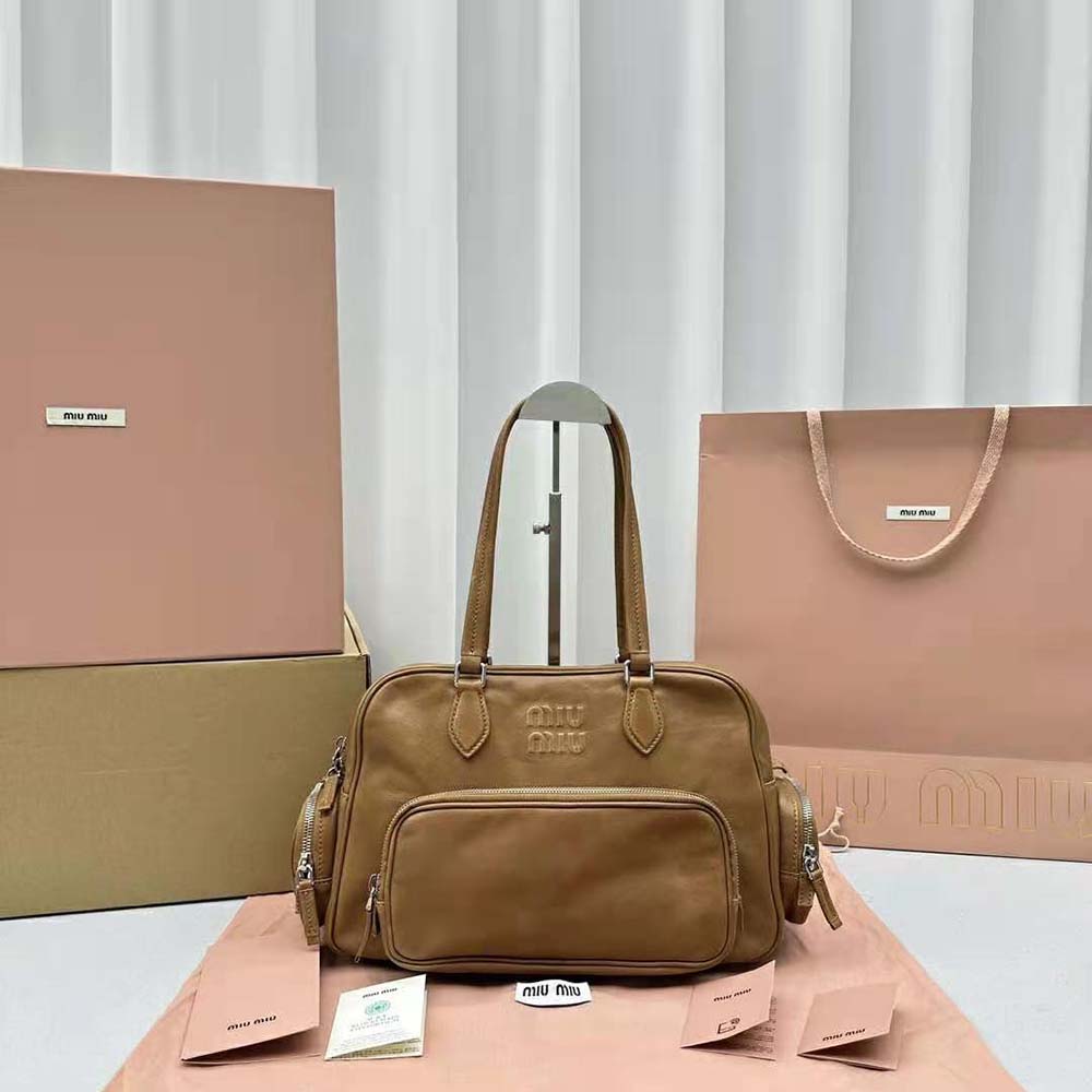 Close-up of embossed lettering logo on Miu Miu brown leather bag