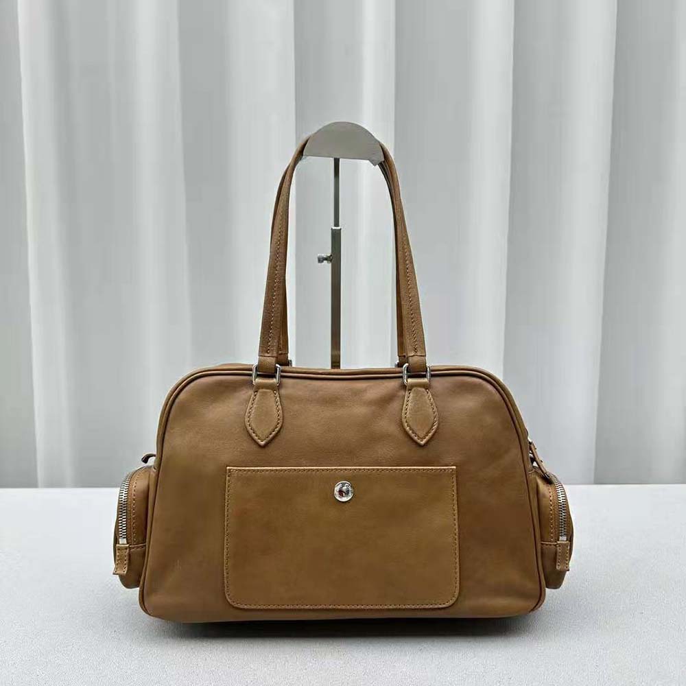 Top-handle and gold hardware details on Miu Miu leather handbag