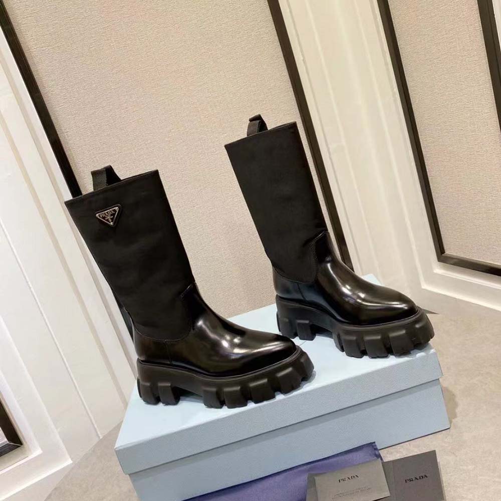 Close-up of lace-up and Prada logo hardware on black boots