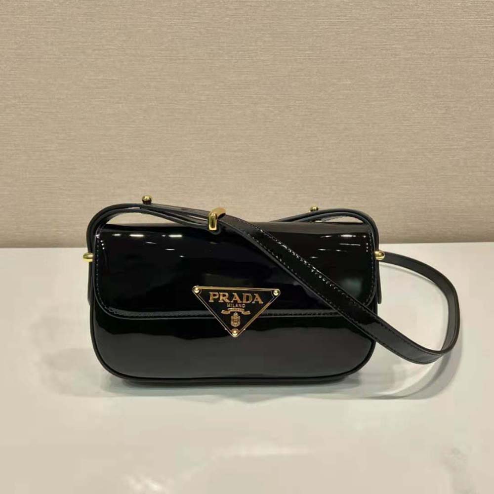 Close-up of Prada logo and silver hardware on black patent leather bag