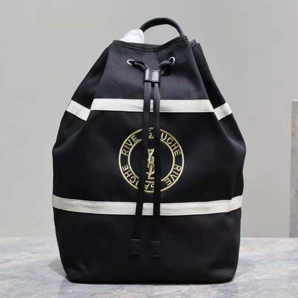 Close-up of silver YSL logo hardware on black canvas sling bag