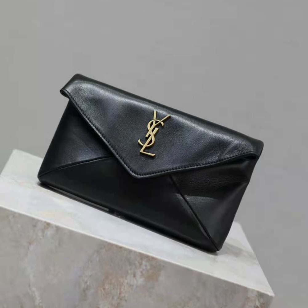Close-up detail of gold YSL logo hardware on black lambskin pouch
