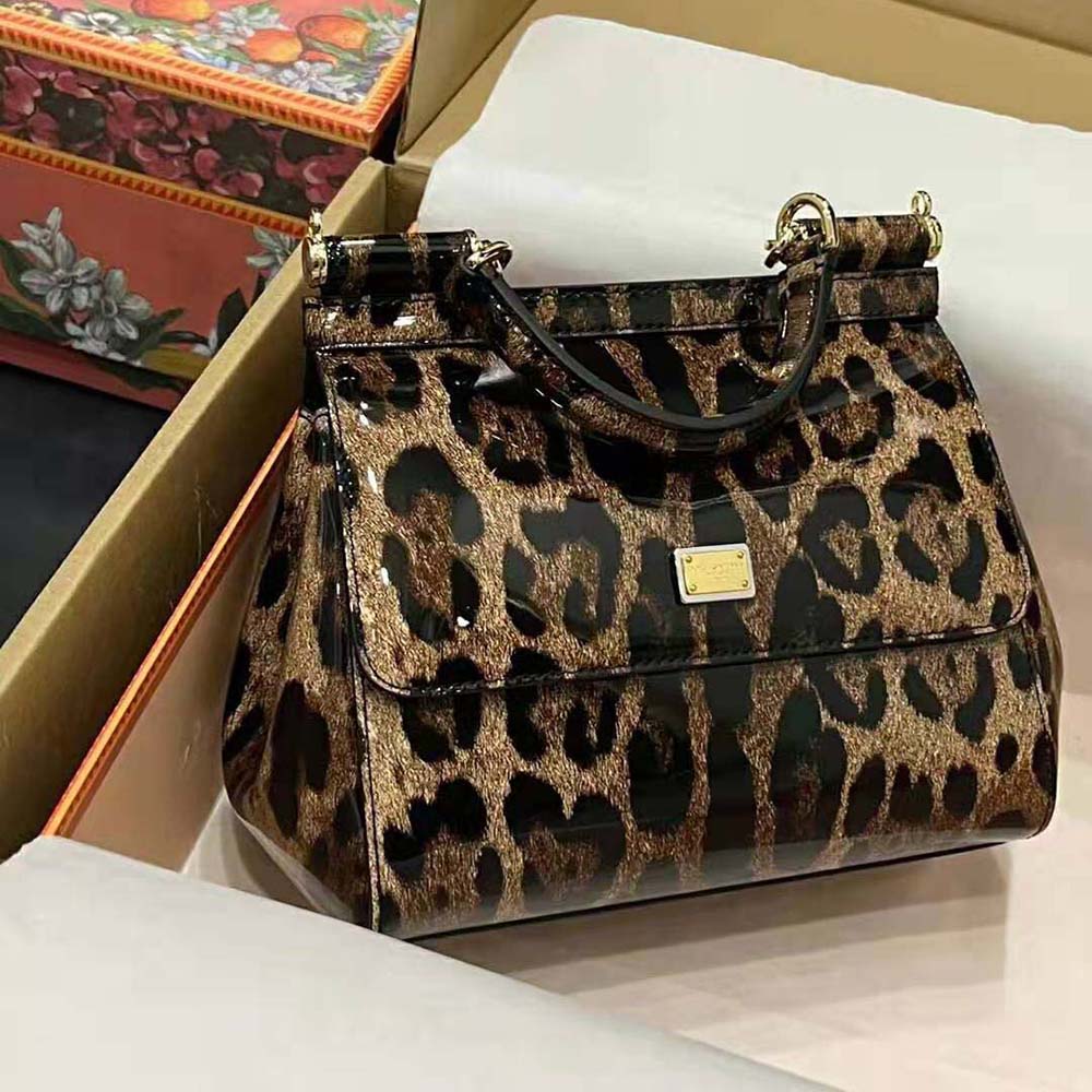 Close-up of gold-tone D&G logo hardware on brown leather handbag