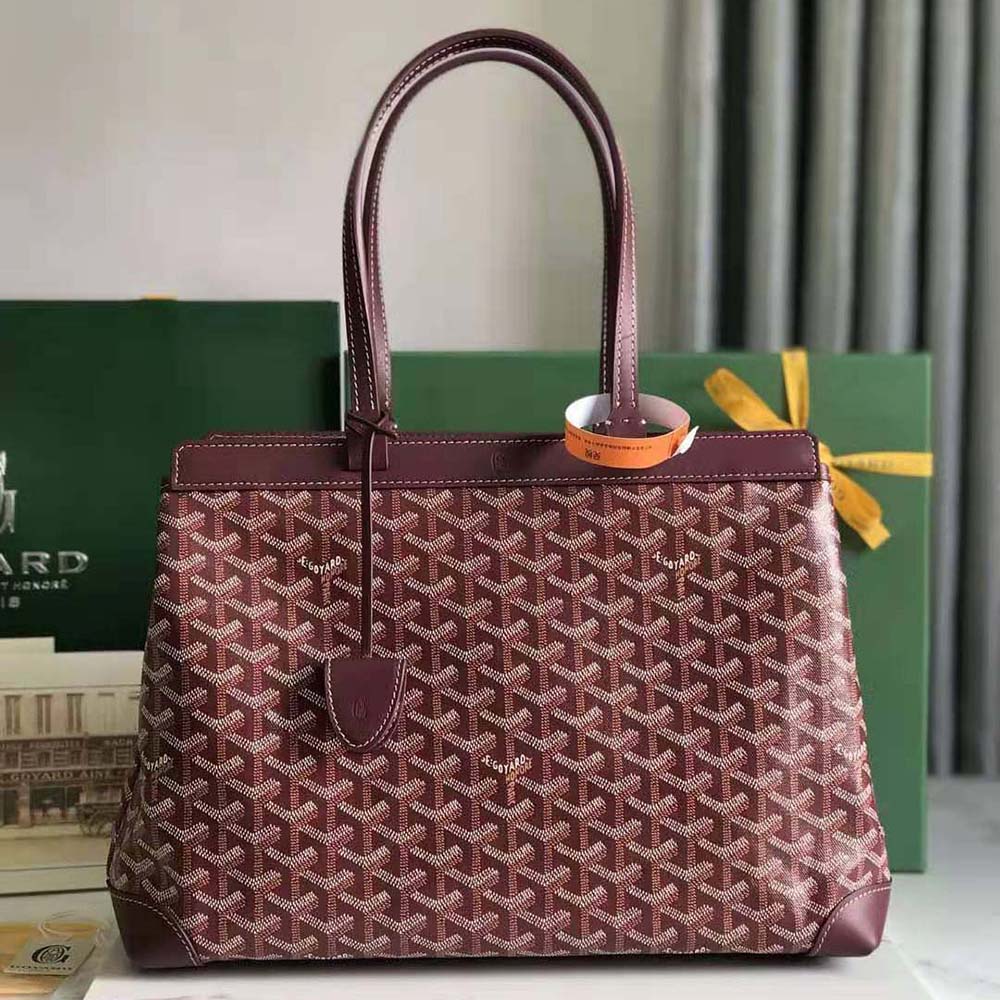 Close-up detail of maroon leather trim and gold clasp on the bag