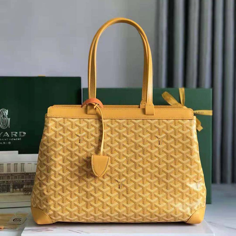Close-up of yellow coated canvas and signature monogram detail on bag