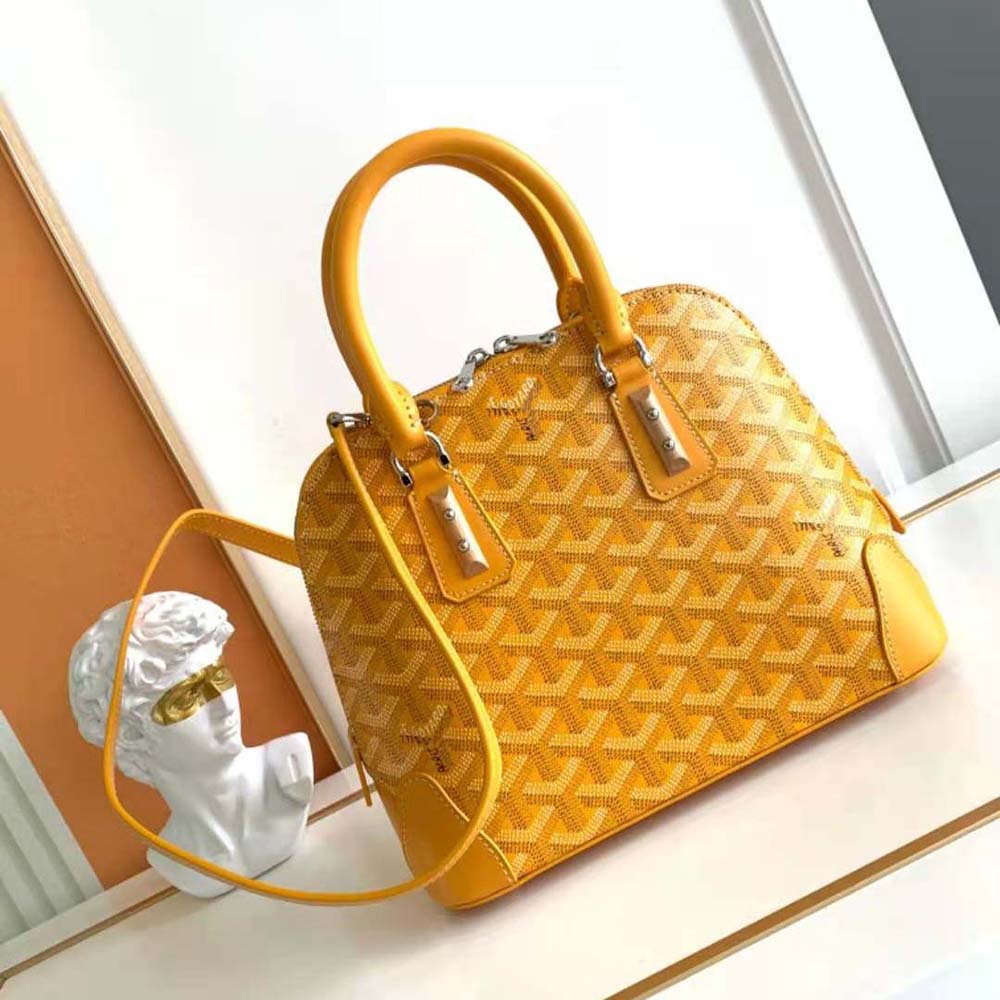 Close-up of yellow coated canvas and gold hardware of Vendôme Mini Bag
