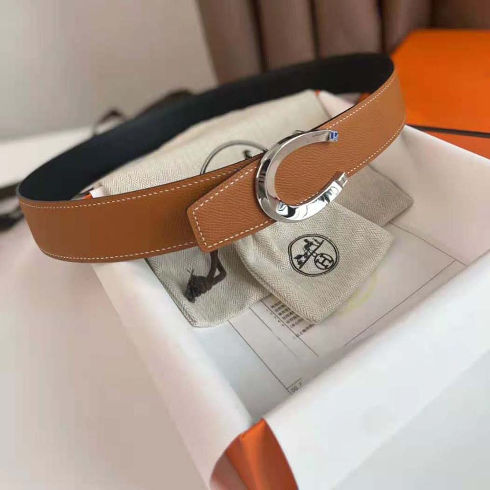 Close-up of polished silver Hermes Luck buckle on brown reversible strap