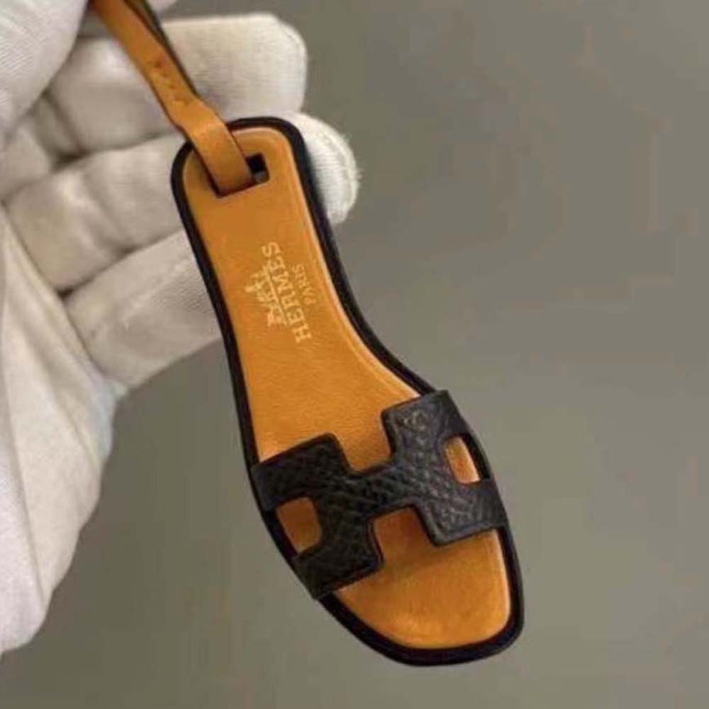 Side angle of Hermes Oran Nano Charm-Black highlighting leather loop